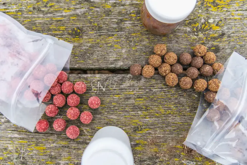 A soft chew treat placed on a wooden table next to a dog's paw