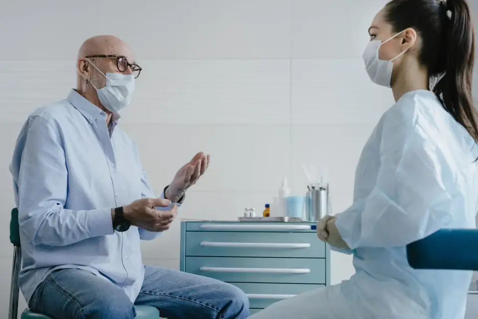 A veterinarian discussing a senior dog's evening symptoms with the owner
